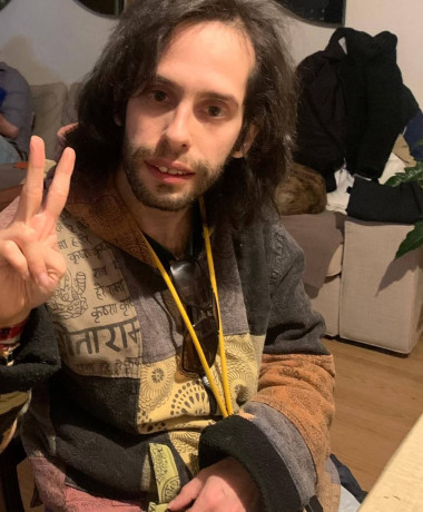 Pedro, com uma samarra típica nepalesa amarela e cabelo comprido e esticado, faz o 